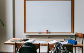 Classroom with whiteboard and desk with stationery