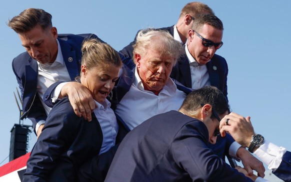 Republican presidential candidate former President Donald Trump is rushed offstage by U.S. Secret Service agents after being grazed by a bullet during a rally on July 13, 2024 in Butler, Pennsylvania. 