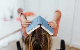 Woman Covering Her Face with a Book