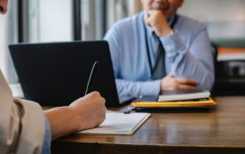 Woman filling job application form in office with boss